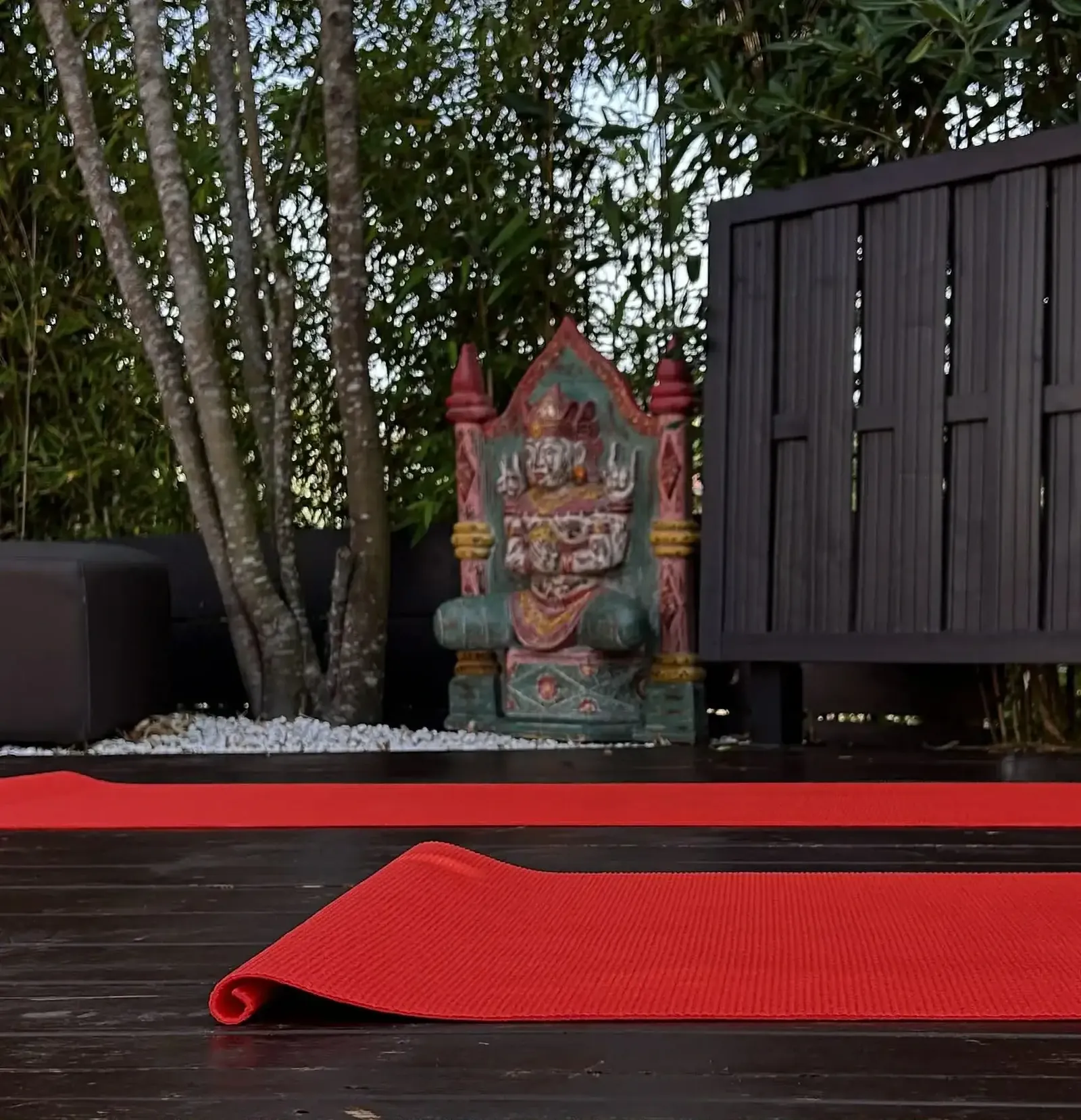 Tapis de yoga rouge déroulé sur la terrasse en bois à Moliets-et-Maa